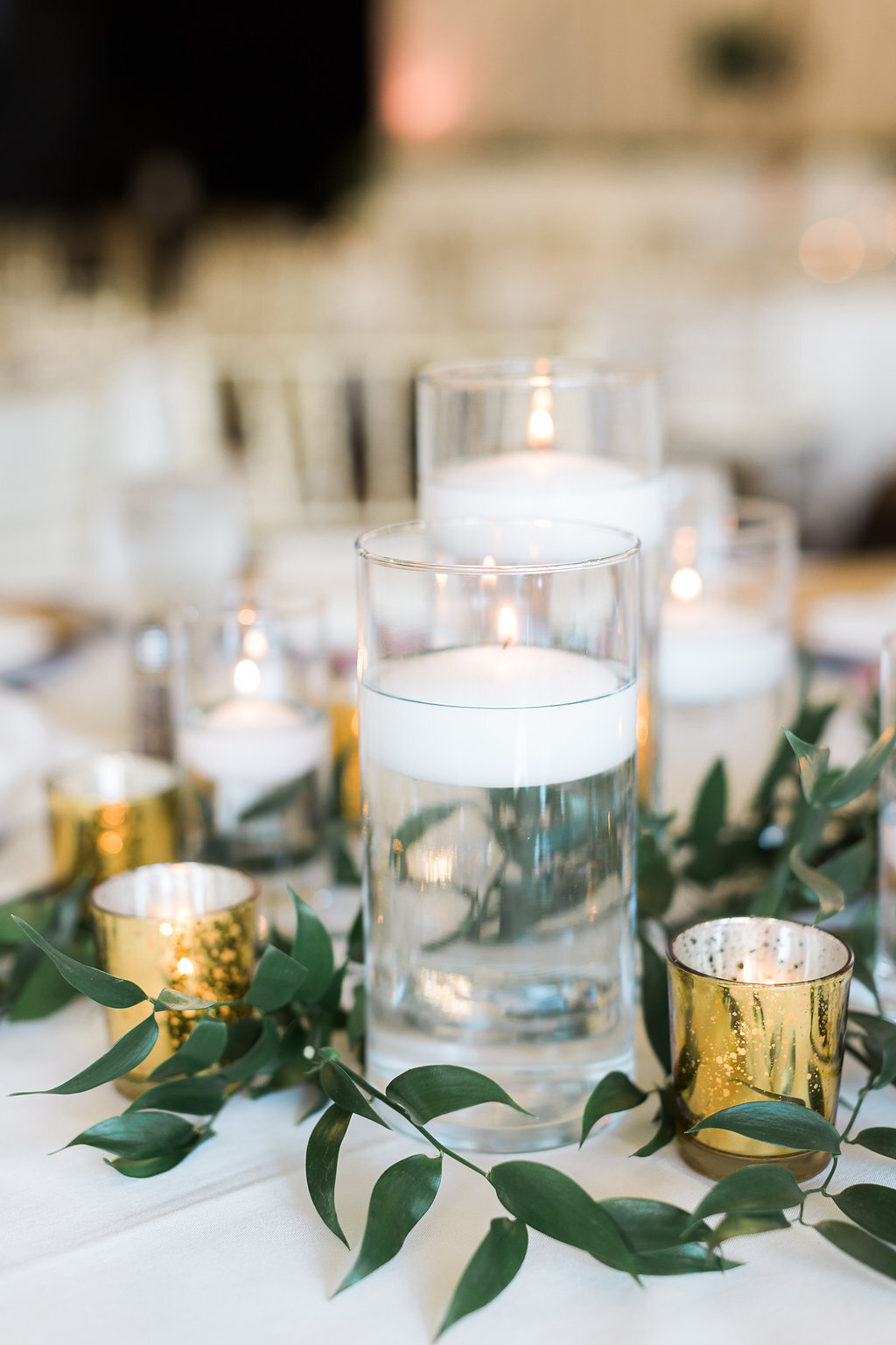 Floating candles with greenery and Gold mercury glass accents.